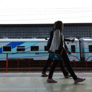 pejalan melewati kereta ekonomi