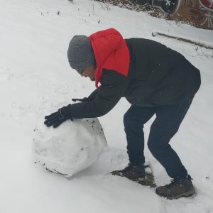 membuat bola salju dengan menggelindingkan bola salju kecil ke salju membuat bola salju dengan menggelindingkan bola salju kecil ke salju