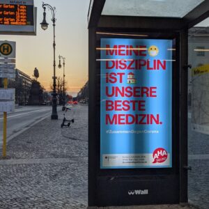 poster bertuliskan "kedisiplinan kita adalah obat terbaik" di halte bus Staatsoper poster bertuliskan "kedisiplinan kita adalah obat terbaik" di halte bus Staatsoper