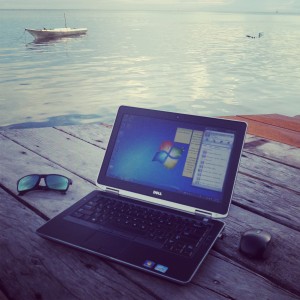 bekerja menggunakan laptop DELL di pinggir laut